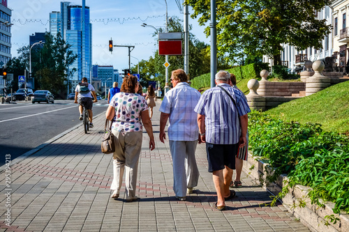 Elderly people walk the streets of the city.