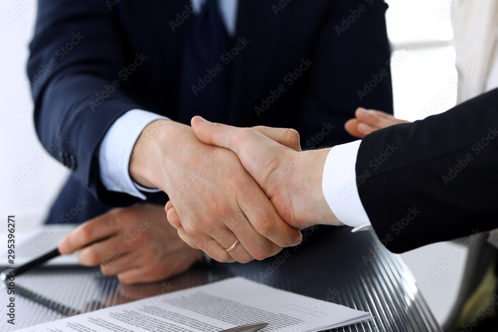 Business people shaking hands after contract signing at the glass desk in modern office. Unknown businessman, male entrepreneur with colleagues at meeting or negotiation. Teamwork, partnership and Business people shaking hands after contract signing at the glass desk in modern office. Unknown businessman, male entrepreneur with colleagues at meeting or negotiation. Teamwork, partnership and