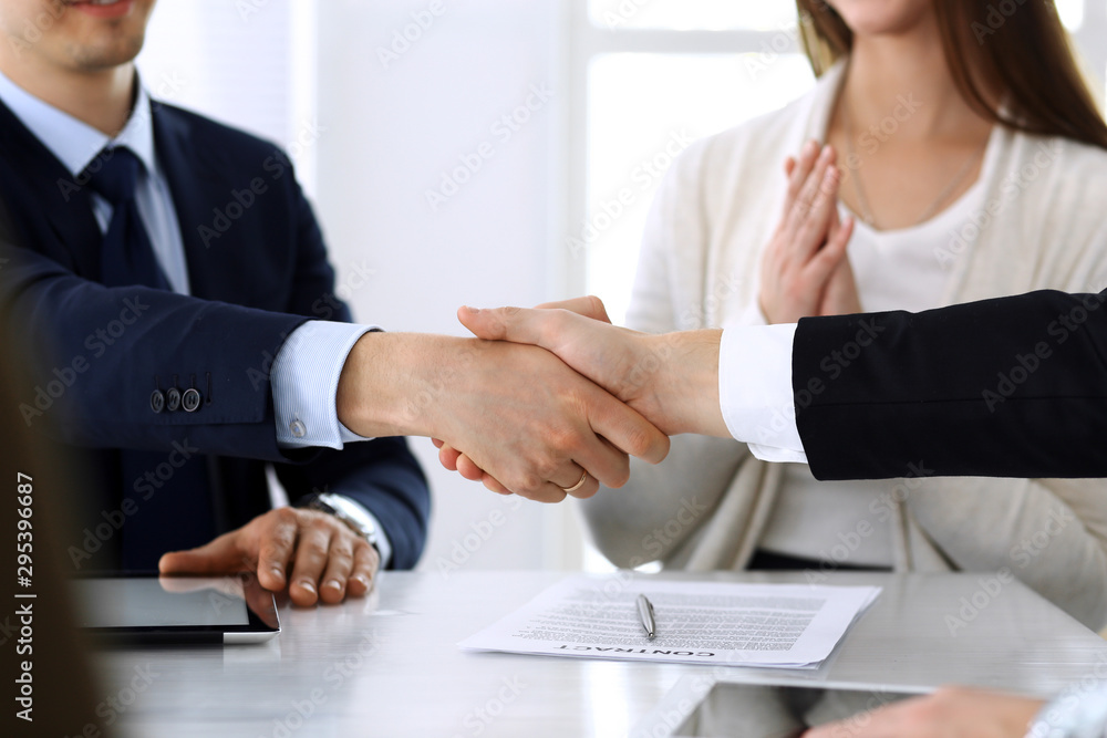 Business people shaking hands after contract signing at the glass desk in modern office. Unknown businessman, male entrepreneur with colleagues at meeting or negotiation. Teamwork, partnership and Business people shaking hands after contract signing at the glass desk in modern office. Unknown businessman, male entrepreneur with colleagues at meeting or negotiation. Teamwork, partnership and