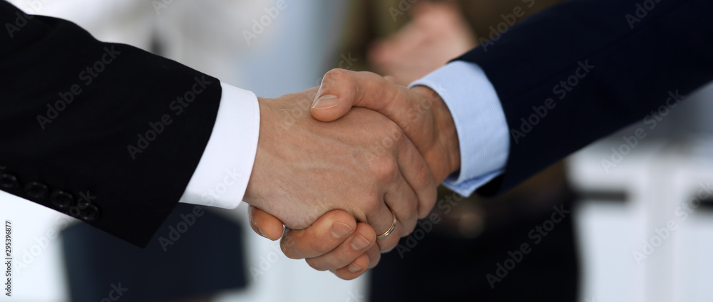 Business people shaking hands after contract signing in modern office. Unknown businessman, male entrepreneur with colleagues at meeting or negotiation. Teamwork, partnership and handshake concept Business people shaking hands after contract signing in modern office. Unknown businessman, male entrepreneur with colleagues at meeting or negotiation. Teamwork, partnership and handshake concept