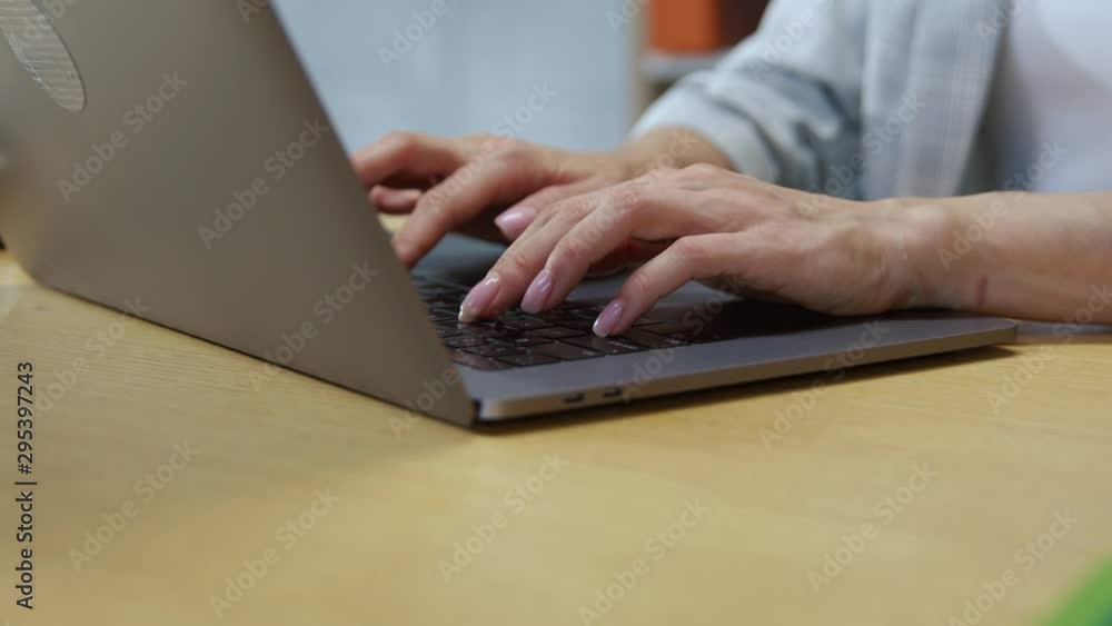 Hands of woman typing on laptop keyboard in working space close-up. Female employee using modern computer at office table. Hands of woman typing on laptop keyboard in working space close-up. Female employee using modern computer at office table.