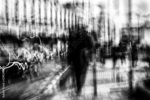 Long exposure of pedestrians walking along the high street - intentional camera shake to introduce an impressionistic effect and light trails - creative filter applied creating a ghostly aesthetic