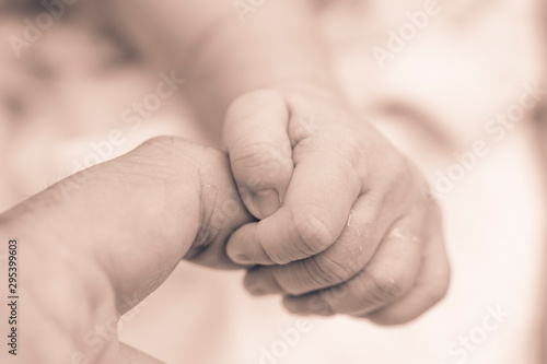 Baby hold mom's hand close up