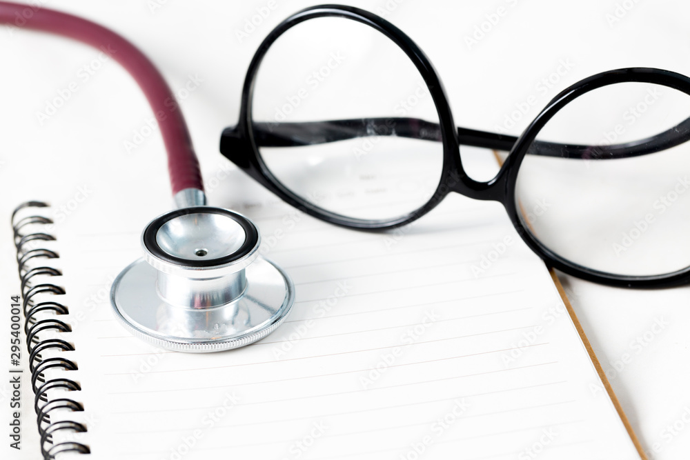 Stethoscope close up on blank notebook for and heart for medical healing concept Stethoscope close up on blank notebook for and heart for medical healing concept