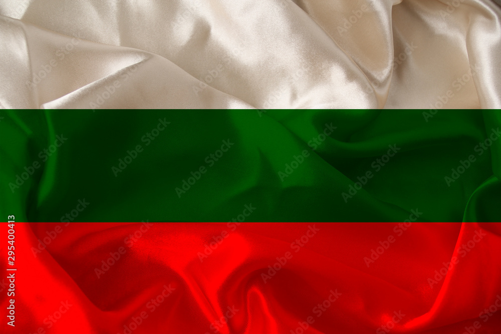 Obraz premium beautiful photo of the colored national flag of the modern state of Bulgaria on textured fabric, concept of tourism, emigration, economy and politics, close up
