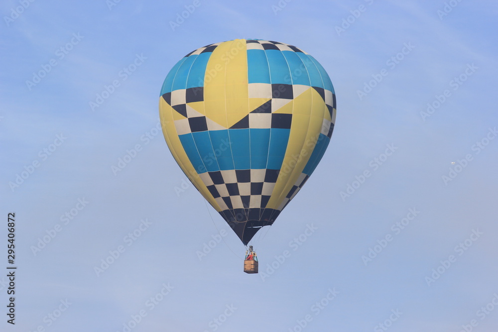 Obraz premium Hot air balloon floating on the blue sky, Colorful with yellow, blue, back and white.