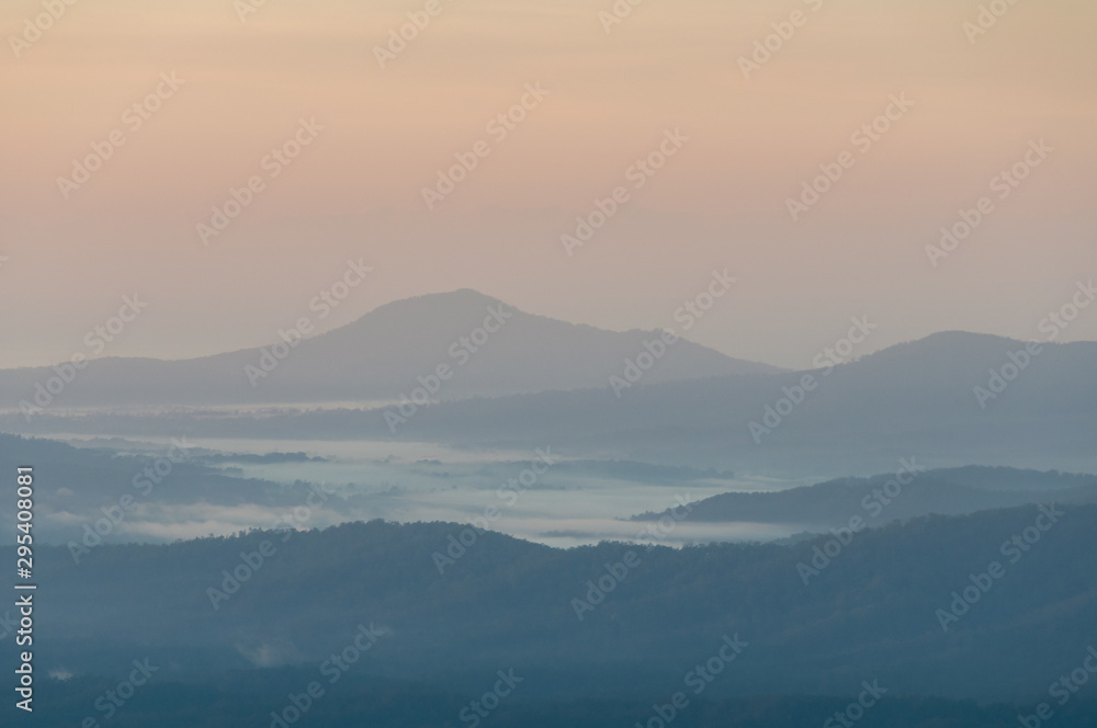 Beautiful nature landscape with mountains in a fog on sunrise