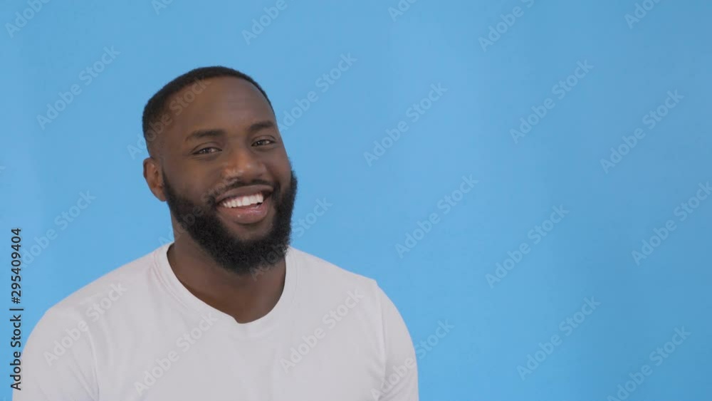 Handsome unshaven young dark-skinned male laughing out loud at funny meme he found on internet, smiling broadly, showing his white straight teeth. Positive human facial expressions and emotions 4K Handsome unshaven young dark-skinned male laughing out loud at funny meme he found on internet, smiling broadly, showing his white straight teeth. Positive human facial expressions and emotions 4K