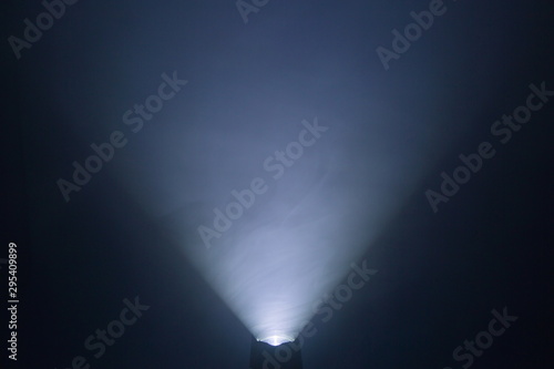 flashlight and light beam in dark mist room at night . abstract projector spotlight white lay growing . photo