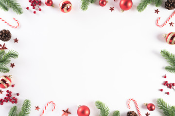 Christmas background concept. Top view of Christmas green gift box with candy cane, snowflakes, red berries and bell on white wooden background.