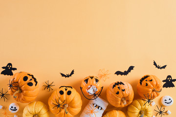 Top view of Halloween crafts, orange pumpkin, white ghost, bat and spider on orange background with copy space for text. halloween concept.