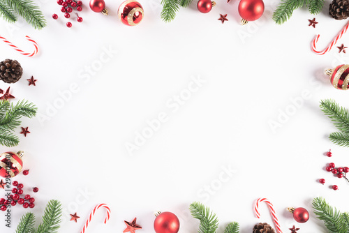 Christmas background concept. Top view of Christmas green gift box with candy cane, snowflakes, red berries and bell on white wooden background.