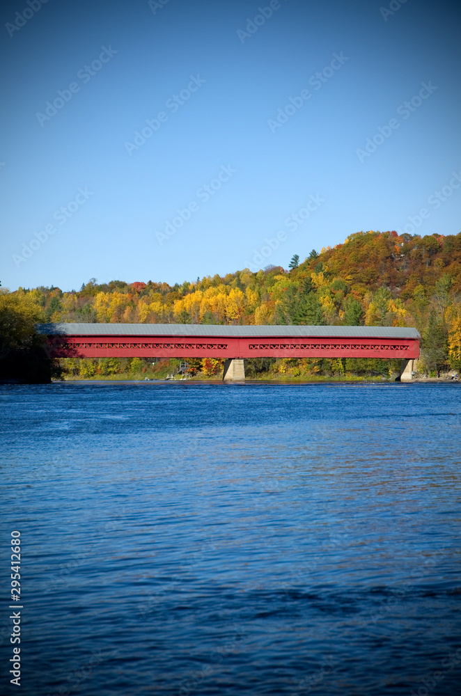 Obraz premium Red Covered Bridge with Colorful Autumn Foliage in Wakefield Quebec, Canada
