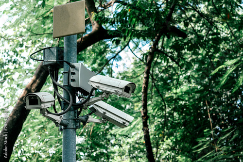 Close up shot of dome security camera (CCTV) installed on a post in a park for surveillance purpose. Horizontal shot. Selective focus. Security concept