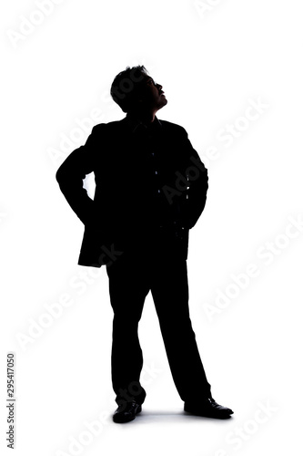 Full body silhouette of a businessman isolated on a white background. He is standing and waiting and posed as if bored or impatient.
