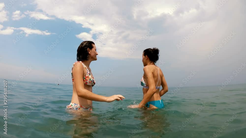 Happy cheerful girl enjoying the rain while playing in the sea Happy cheerful girl enjoying the rain while playing in the sea