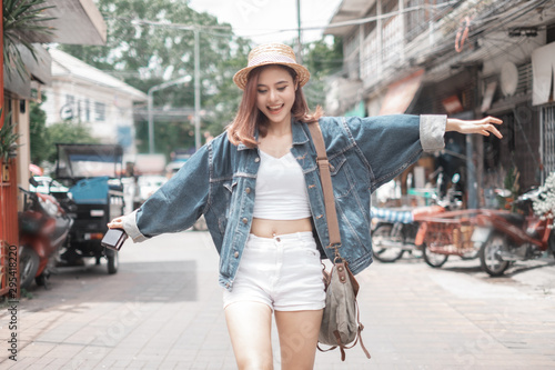 Smiling woman traveler in chiangmai market landmark chiangmai thailand holding camera with backpack on holiday, relaxation concept, travel concept