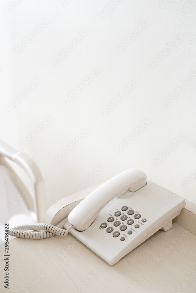 White telephone handset Placed on a table in a white room White telephone handset Placed on a table in a white room
