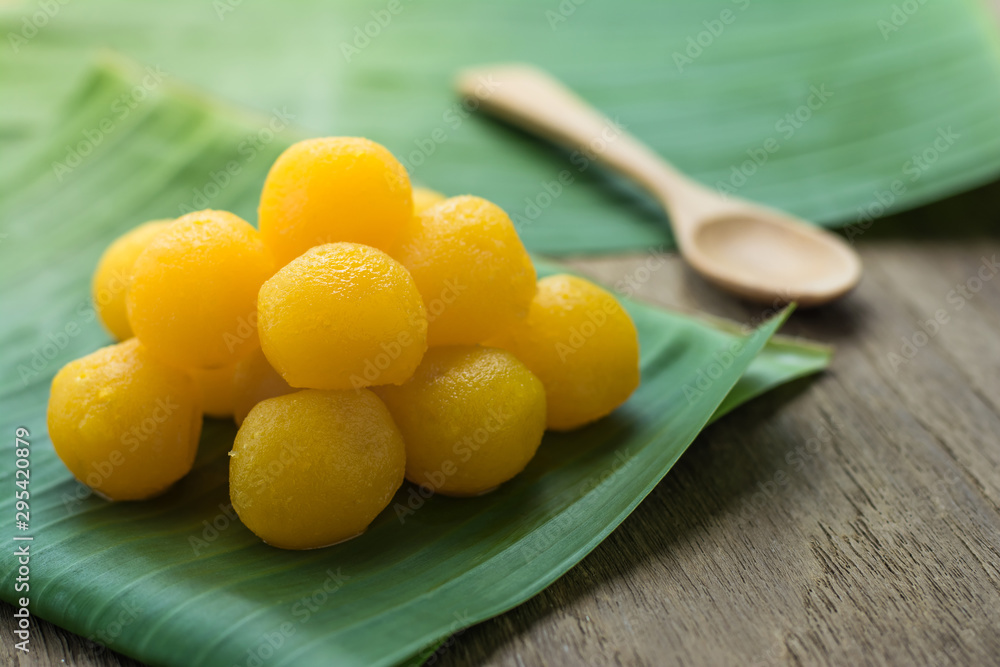Thai traditional desserts Gold Egg Yolks Drops on the banana leaves , Wooden top table Thai traditional desserts Gold Egg Yolks Drops on the banana leaves , Wooden top table