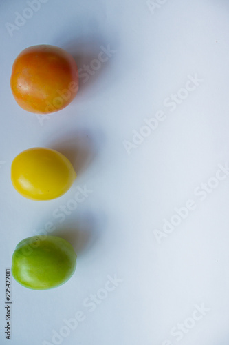 Red, yellow, green tomato on a white background. copy space, top view, flat lay, background with blank space for text