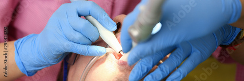 Female hand in blue protective gloves conducts professional oral hygiene closeup. Patient on admission to the dentist paid clinic payment for health insurance concept