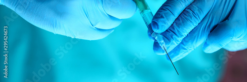 Physician injector arms in sterile uniform holding syringe while operating patient in surgical theatre closeup. HIV protection aids medication botulinum toxin innovation 911 team concept