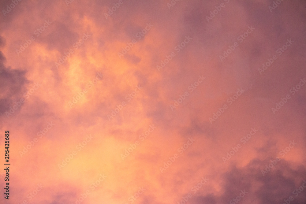 Pink, purple, orange golden glow of clouds at sunset against blue sky ideal as nature background