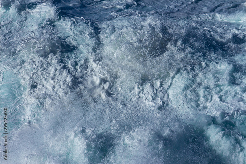 Aquatic background of sea surf waves splashing close up with clear blue green water and white foam © squirrel7707