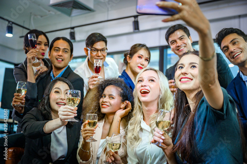 A group of business people holding a glass of champagne in a party to celebrate their success