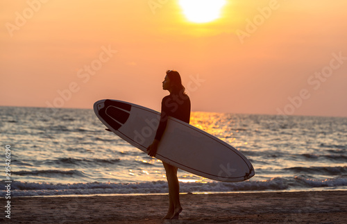 Water sport bodyboarding surfer woman on summer beach vacation holidays travel. Surfing girl holding bodyboard looking at ocean sea and sunshine.