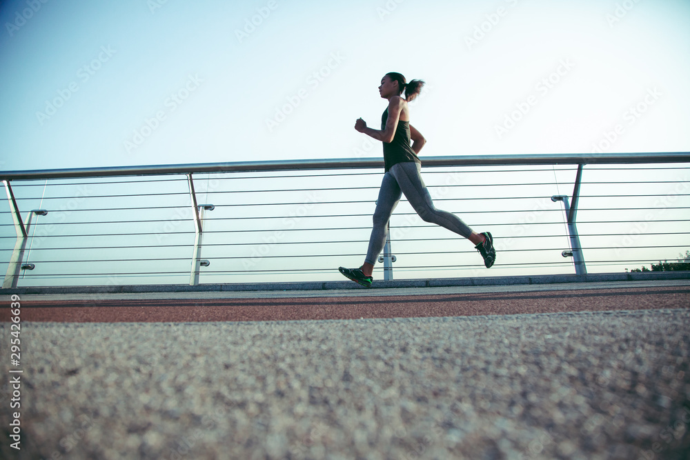 Sportswoman running at daytime alone stock photo