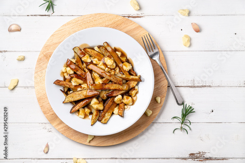 Montreal poutine from above view. A classic fast food cuisine dish from Quebec. This canadian comfort food is made with french fries mixed with tasty cheese curds and a delicious brown gravy sauce.