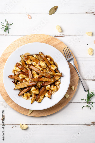 Canadian poutine dish top view. A classic fast food cuisine dish from Quebec. This canadian comfort food is made with french fries mixed with tasty cheese curds and a delicious brown gravy sauce. photo