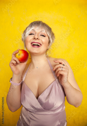 Close up pretty young woman holding an apple she's about to eat