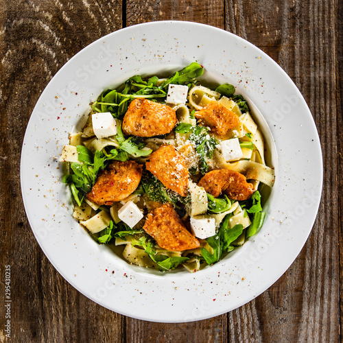 Pasta with chicken meat, feta cheese and rucola