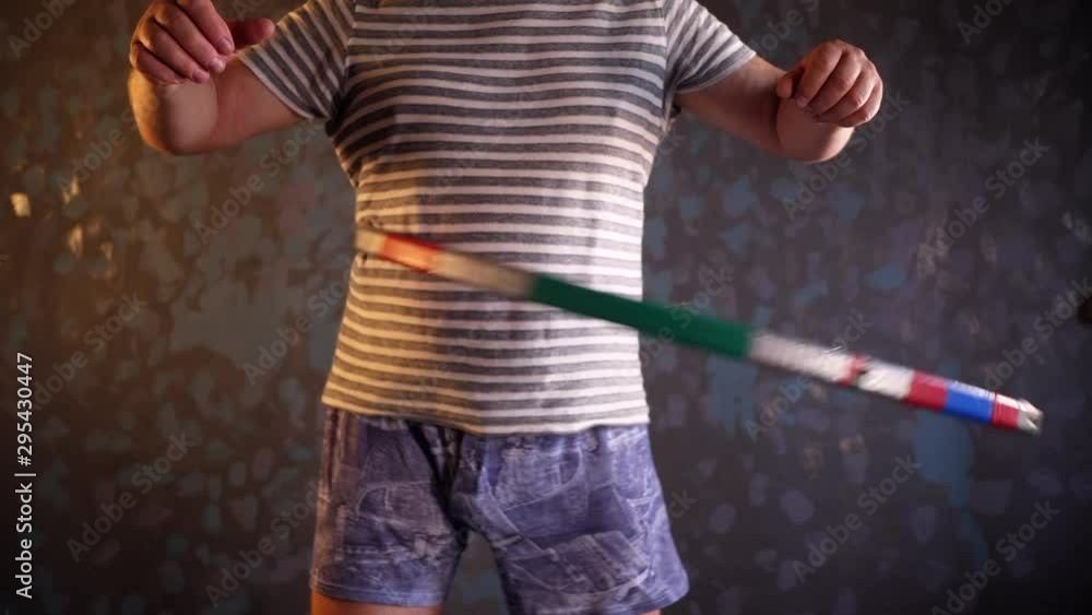 concept of gymnastics, sports at home, healthcare. elderly pensioner in striped T-shirt rotates hoop with all his might. Exercise is good for health and fitness. Healthy lifestyle concept of gymnastics, sports at home, healthcare. elderly pensioner in striped T-shirt rotates hoop with all his might. Exercise is good for health and fitness. Healthy lifestyle