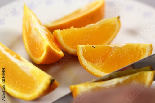 Slicing orange with knife