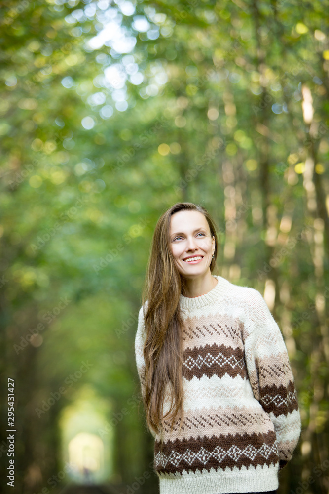 Beauitful woman wearing sweater walking in autumn forest Beauitful woman wearing sweater walking in autumn forest