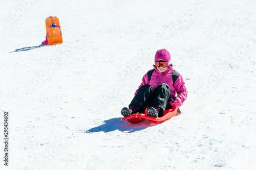 Little girl sledding at Sierra Nevada ski resort.