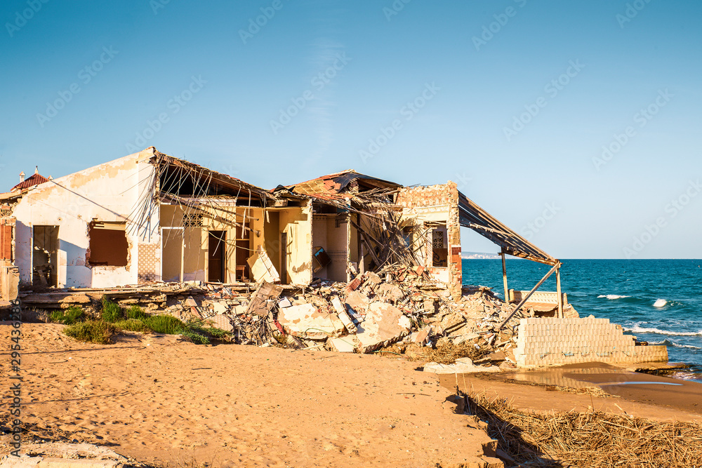 ruined house on the beach after a storm due to strong waves. Climate change ruined house on the beach after a storm due to strong waves. Climate change
