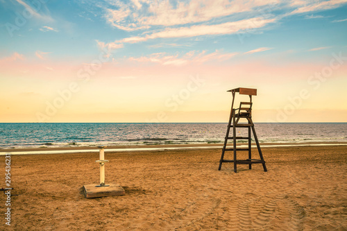 Baywatch chair on secluded beach at sunset in Guardamar. Alicante, Spain