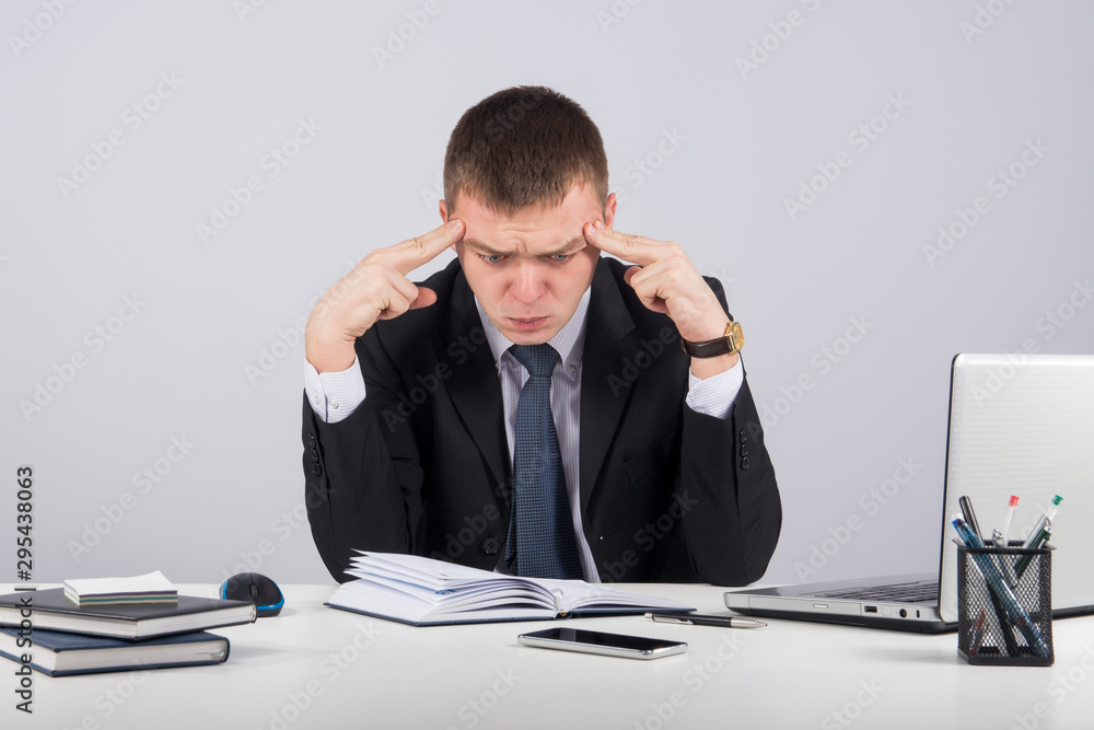 Frustrated young businessman working on laptop computer at office Frustrated young businessman working on laptop computer at office