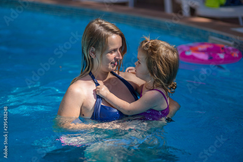 Mother teaching baby to swim in water pool © Evgeniy Agarkov