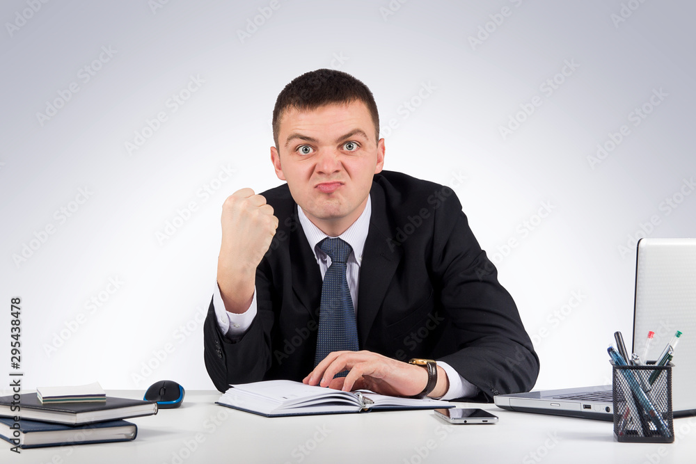 Office, finances, internet, business, success concept-Portrait of a young angry businessman showing you his fist Office, finances, internet, business, success concept-Portrait of a young angry businessman showing you his fist