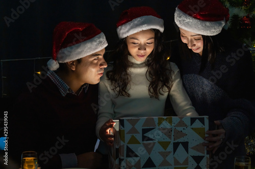 A little girl with family opening magical box on Christmas day