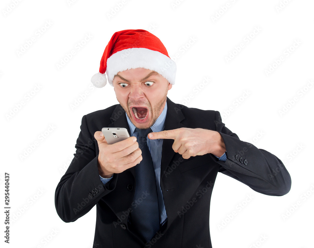 Angry businessman in santa claus hat is talking on the phone and screams of joy Angry businessman in santa claus hat is talking on the phone and screams of joy