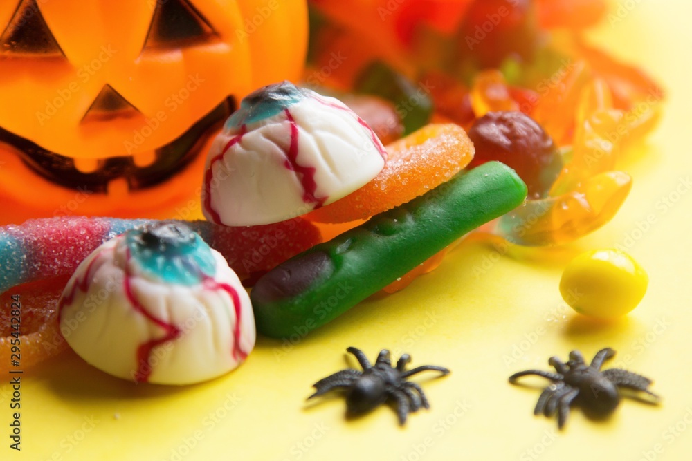 halloween candies seen close up on yellow background