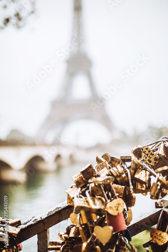 Locks of couples in love hang on metal bars on the background of the Eiffel tower Paris