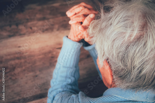 The old person's praying hand. Concept: hope, belief, dramatic loneliness, sadness, depression, cry, disappointed, healthcare, pain.
