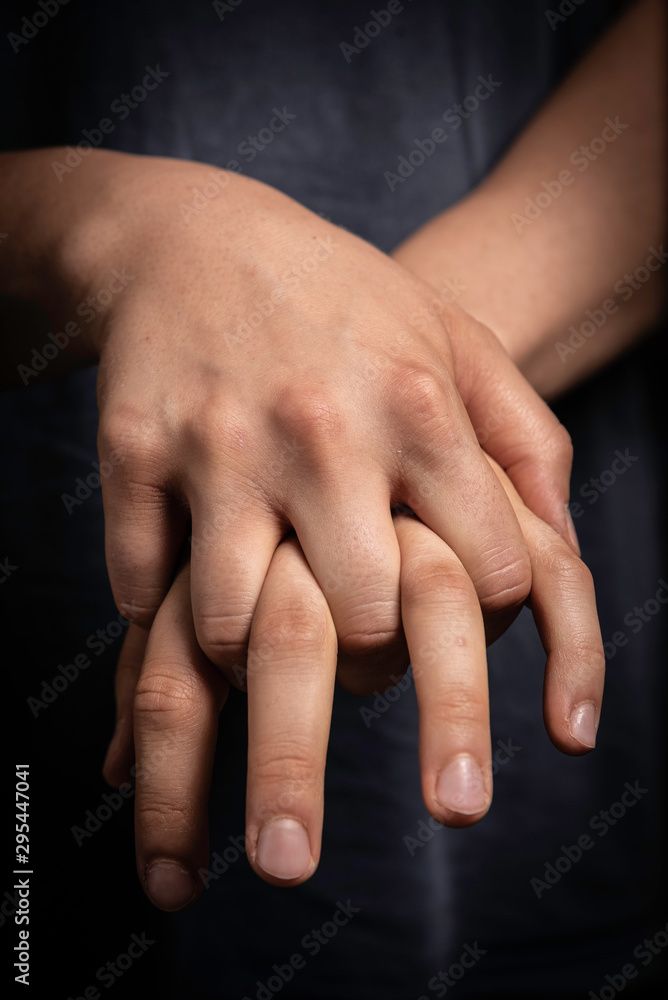 Human with fingers interlocked, nervous gesture close up